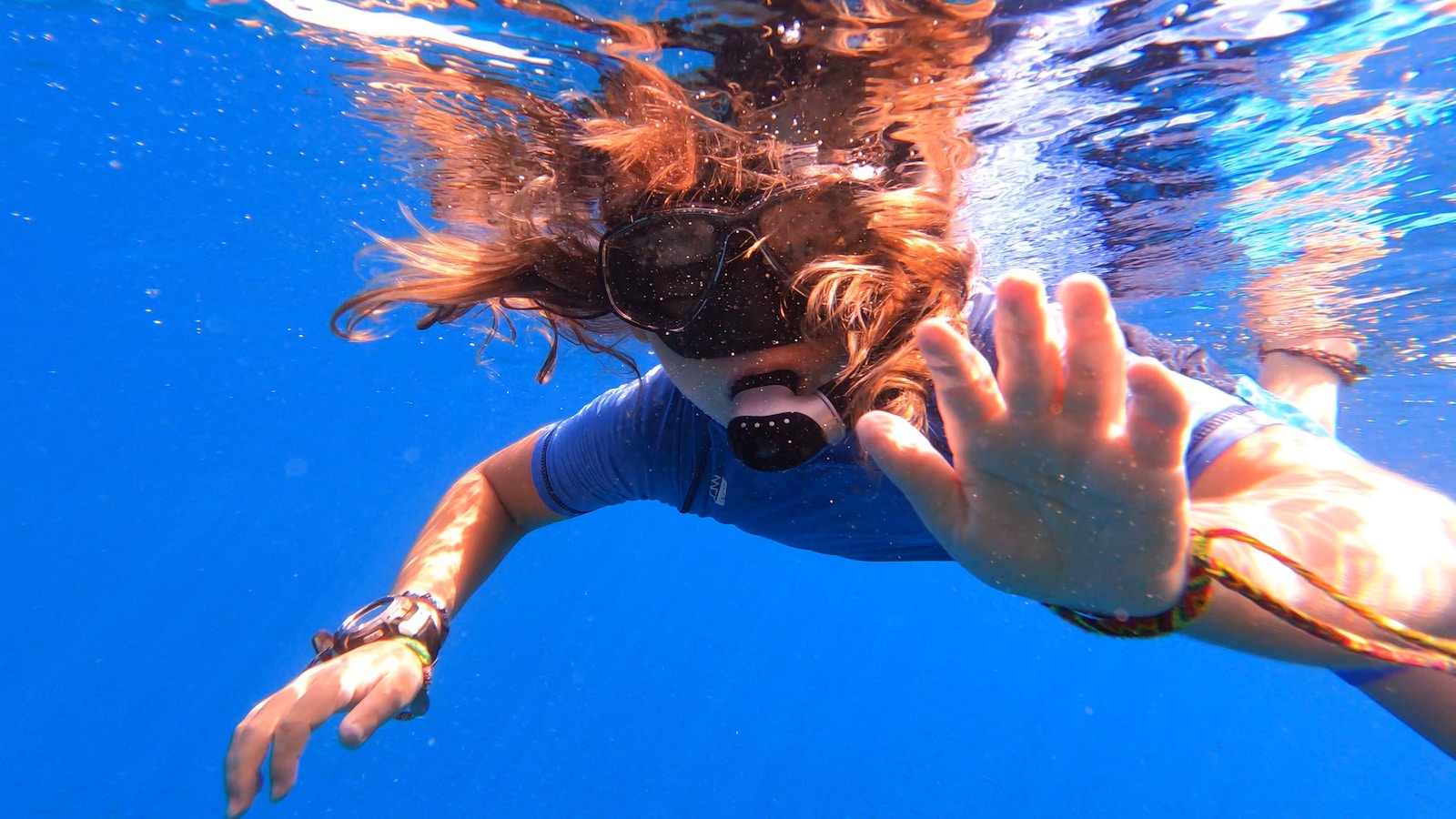 woman in white and blue floral bikini top and blue denim jeans under water